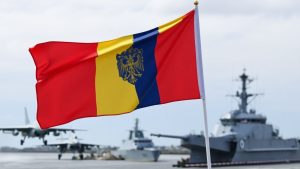 Steagul României flutură lângă avioane și nave militare.